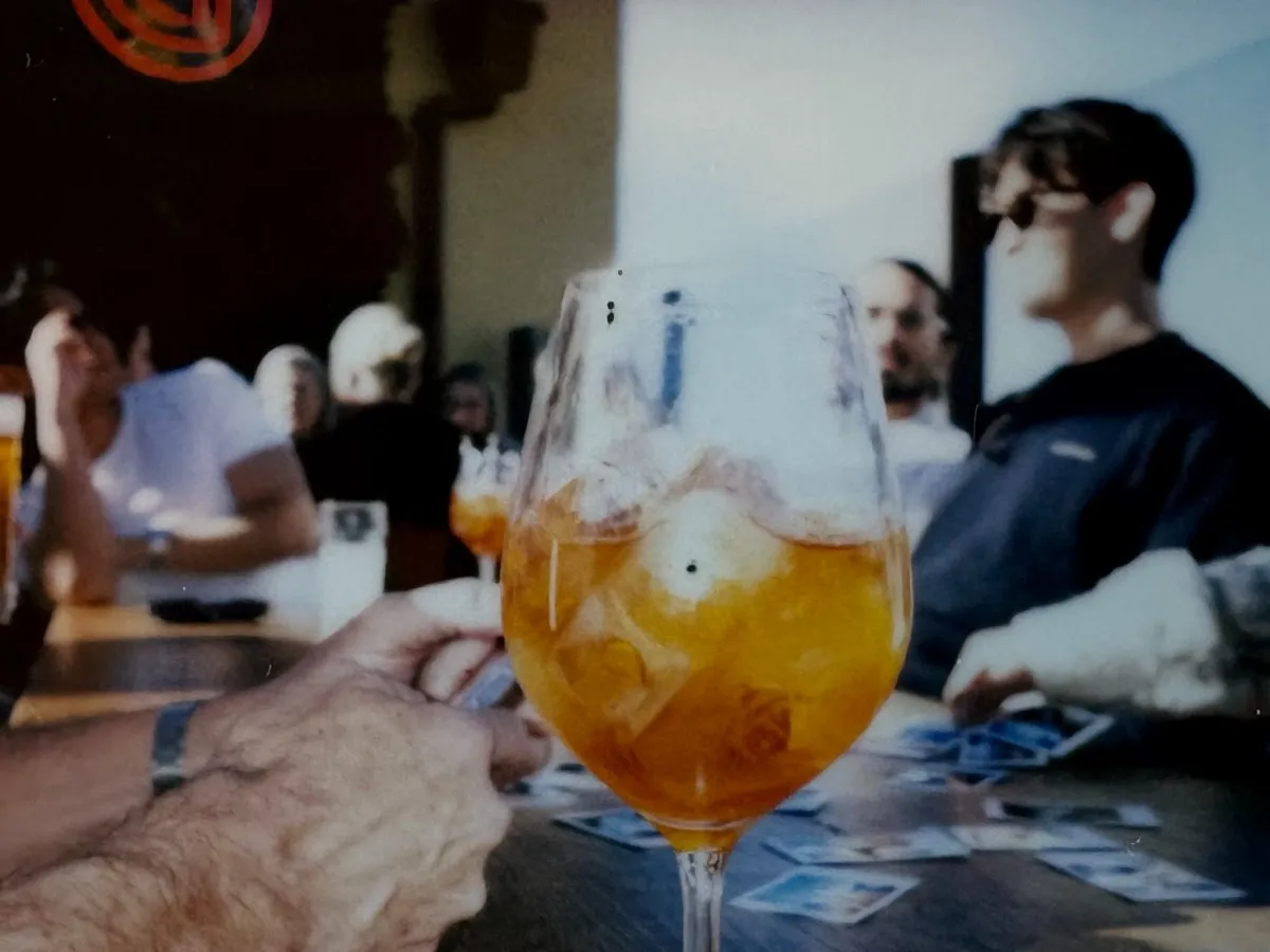 Aperol spritz on a long bar table with the team in the background